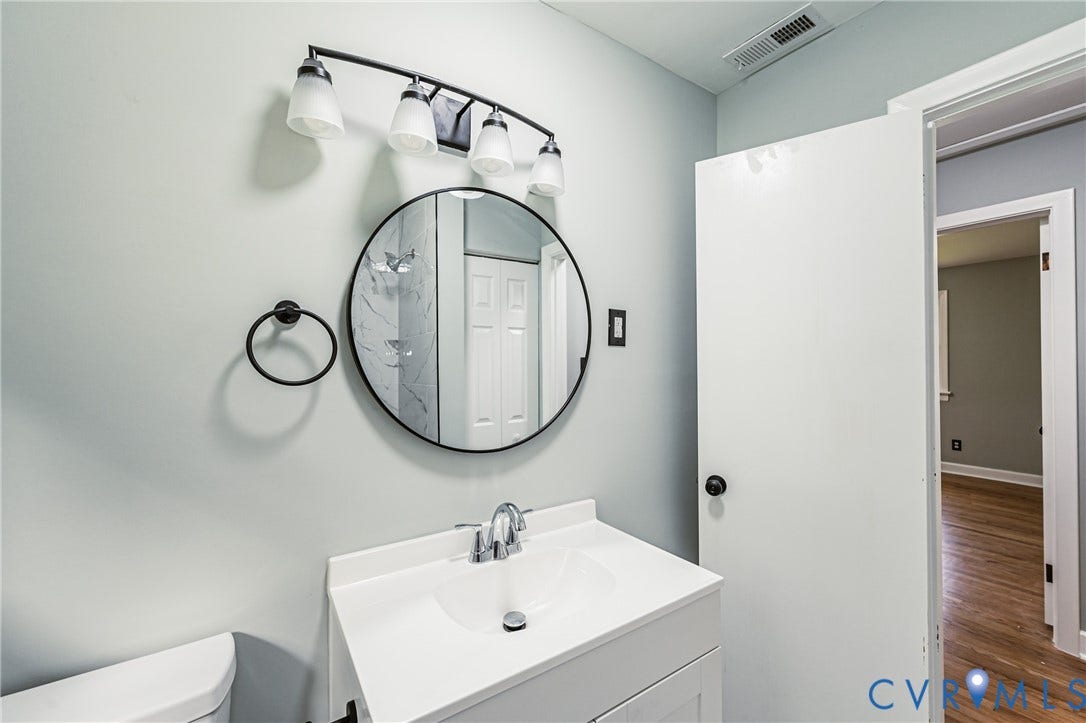 1724 Alaska Drive, Richmond, VA 23224 Single vanity with integrated sink, chrome faucet, and white cabinetry