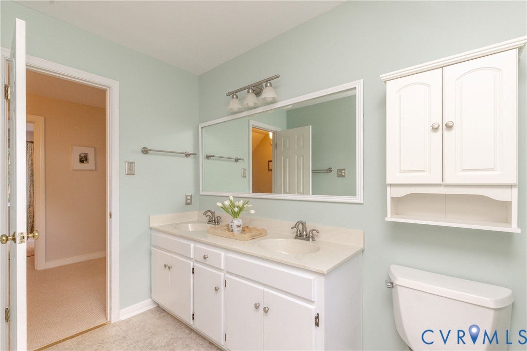 2120 Willowick Lane, Henrico, VA 23238 Double vanity with integrated sinks, white cabinetry, a wall-mounted mirror, and overhead lighting fixture