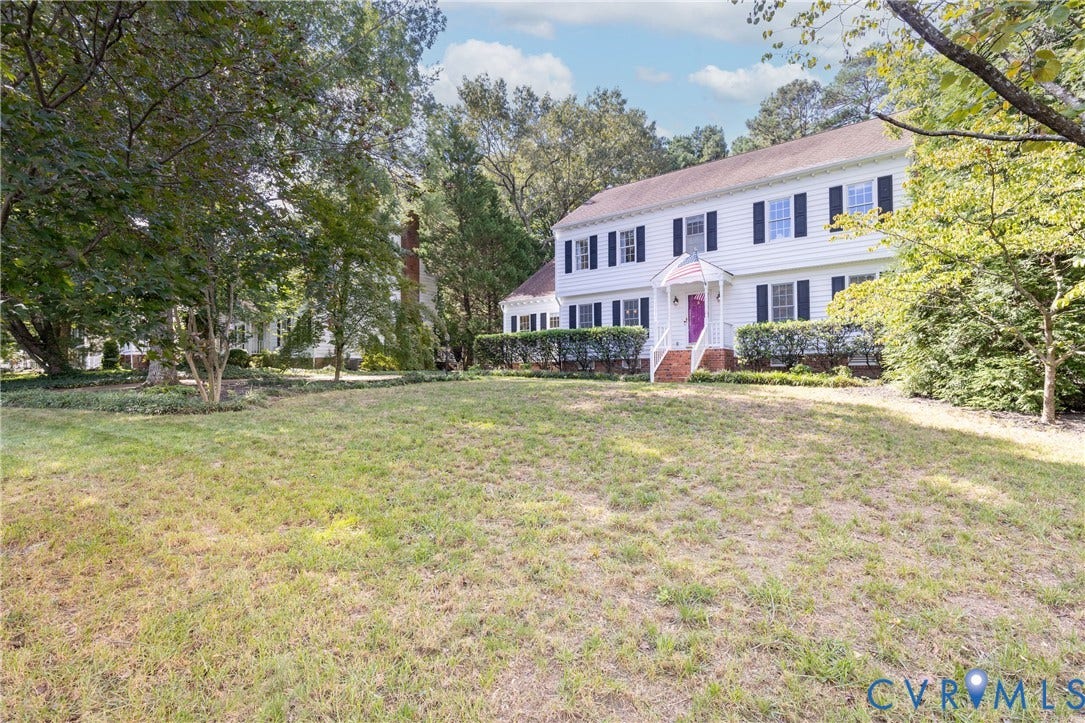 2120 Willowick Lane, Henrico, VA 23238 Two-story Colonial-style home with white siding, dark shutters, a front porch with white railings, and a prominent chimney