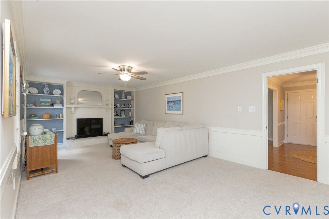 2120 Willowick Lane, Henrico, VA 23238 Living area with fireplace, built-in shelving, ceiling fan, crown molding, and wainscoting