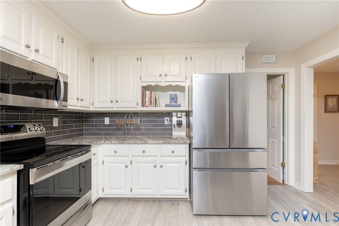2120 Willowick Lane, Henrico, VA 23238 White cabinetry with brushed nickel hardware, stainless steel appliances, grey subway tile backsplash, light-toned wood-finish flooring, and light-toned countertops