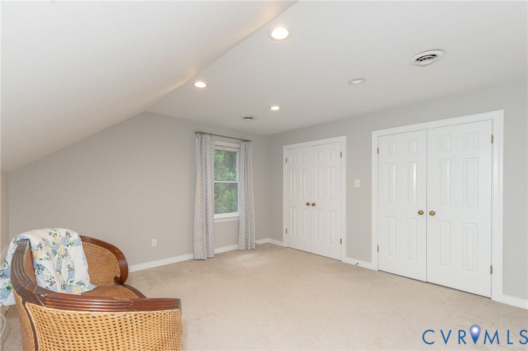 2120 Willowick Lane, Henrico, VA 23238 Sloped ceiling with recessed lighting, light-toned carpeting, two white paneled closet doors, and a window with natural light