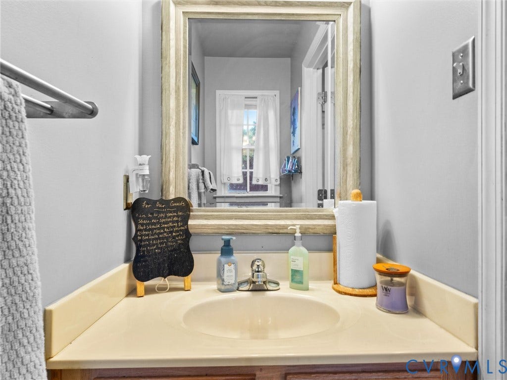 6507 Fairpines Road, North Chesterfield, VA 23234 First floor powder room. Vanity featuring a built-in sink, single-handle faucet, and framed mirror