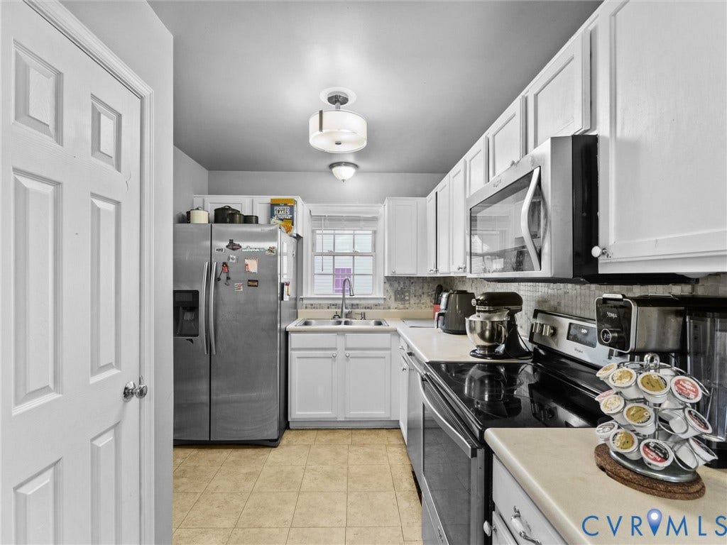 6507 Fairpines Road, North Chesterfield, VA 23234 Well-appointed kitchen featuring white cabinetry, stainless steel appliances, a tile backsplash, and a double-basin sink with a gooseneck faucet