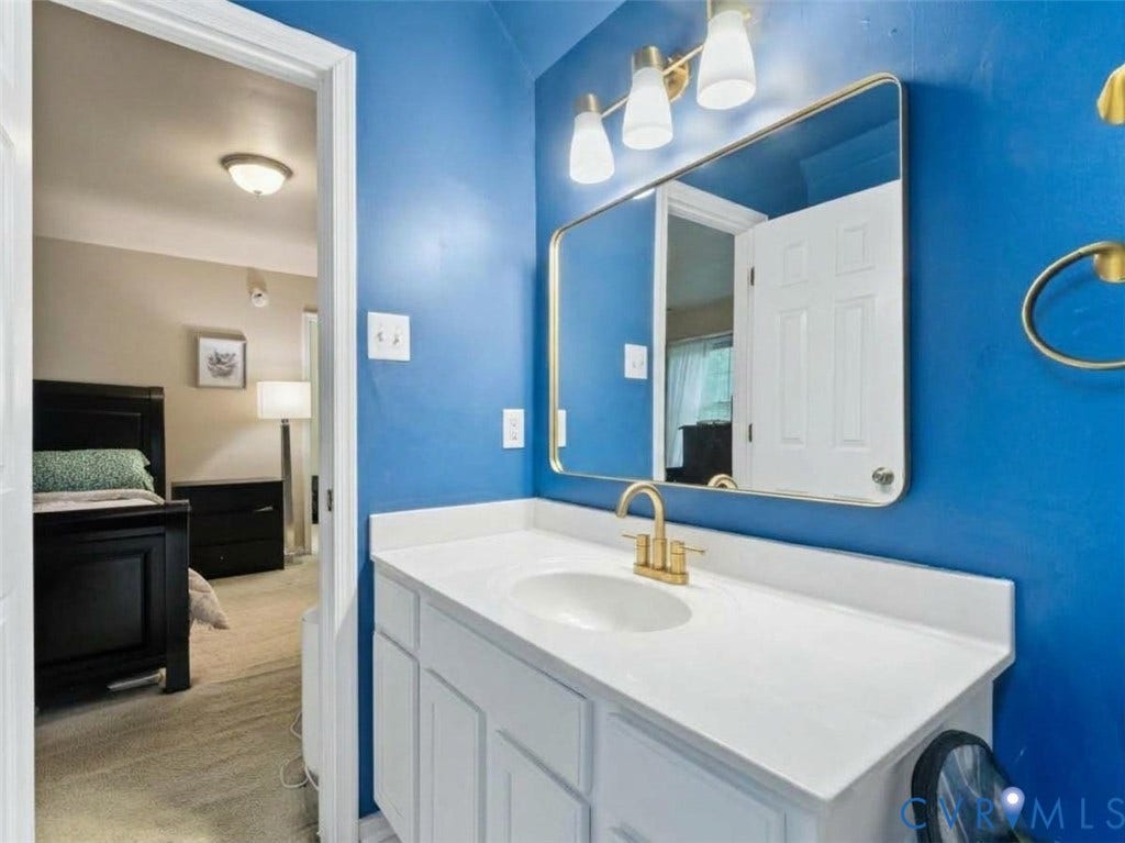 6507 Fairpines Road, North Chesterfield, VA 23234 Vanity with white countertop, gold-finish faucet, and coordinating wall-mounted mirror