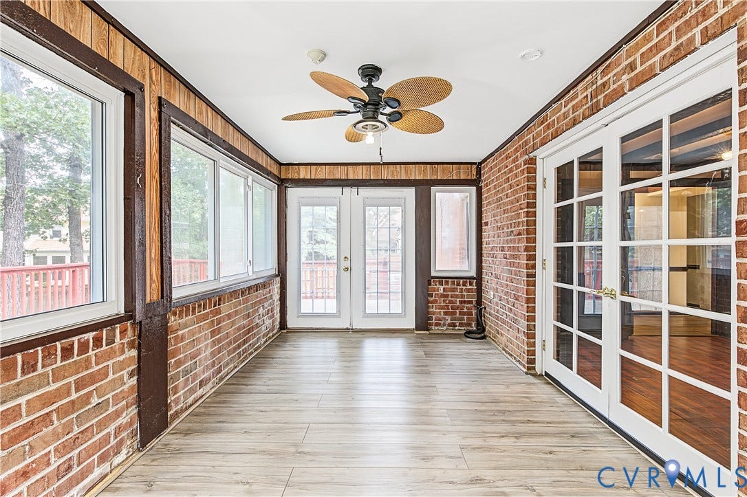 13310 Gladehill Road, Hidden Valley Estates, Chesterfield, VA 23831 Enclosed porch with wood-finish flooring, exposed brick walls, wood paneling, multiple windows, and a ceiling fan