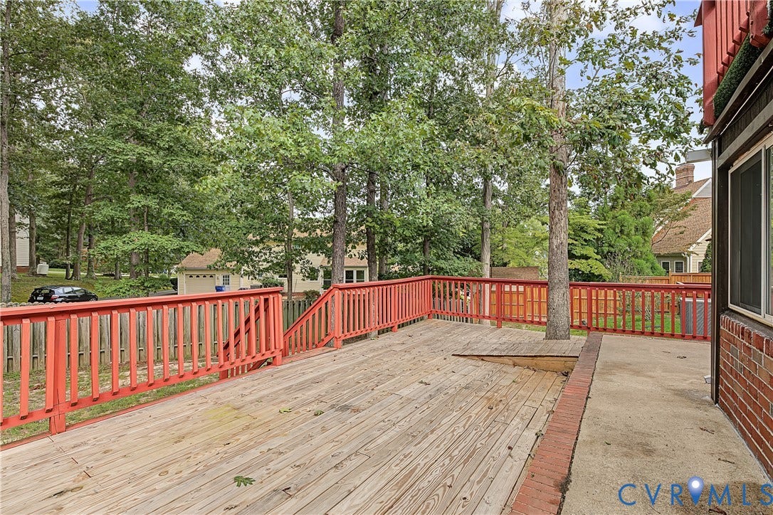 13310 Gladehill Road, Hidden Valley Estates, Chesterfield, VA 23831 Expansive wood deck with vibrant red railing, integrated tree feature, and a concrete patio section