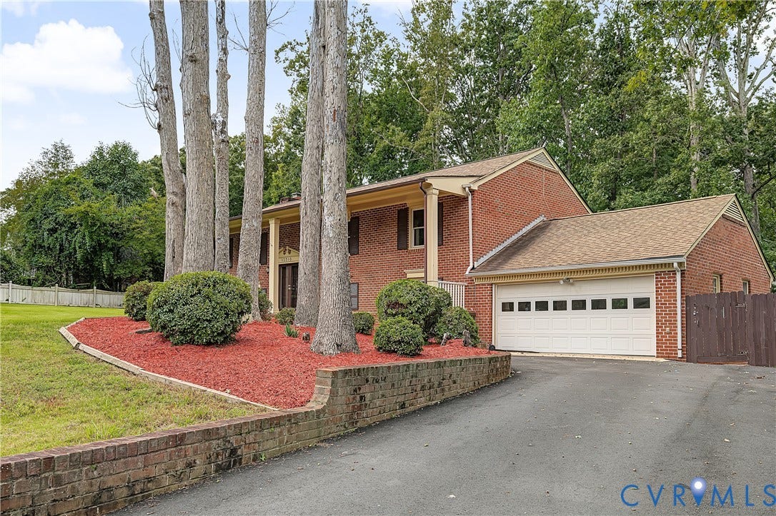 13310 Gladehill Road, Hidden Valley Estates, Chesterfield, VA 23831 Brick exterior with a prominent two-car garage, mature trees, and a landscaped front garden with red mulch