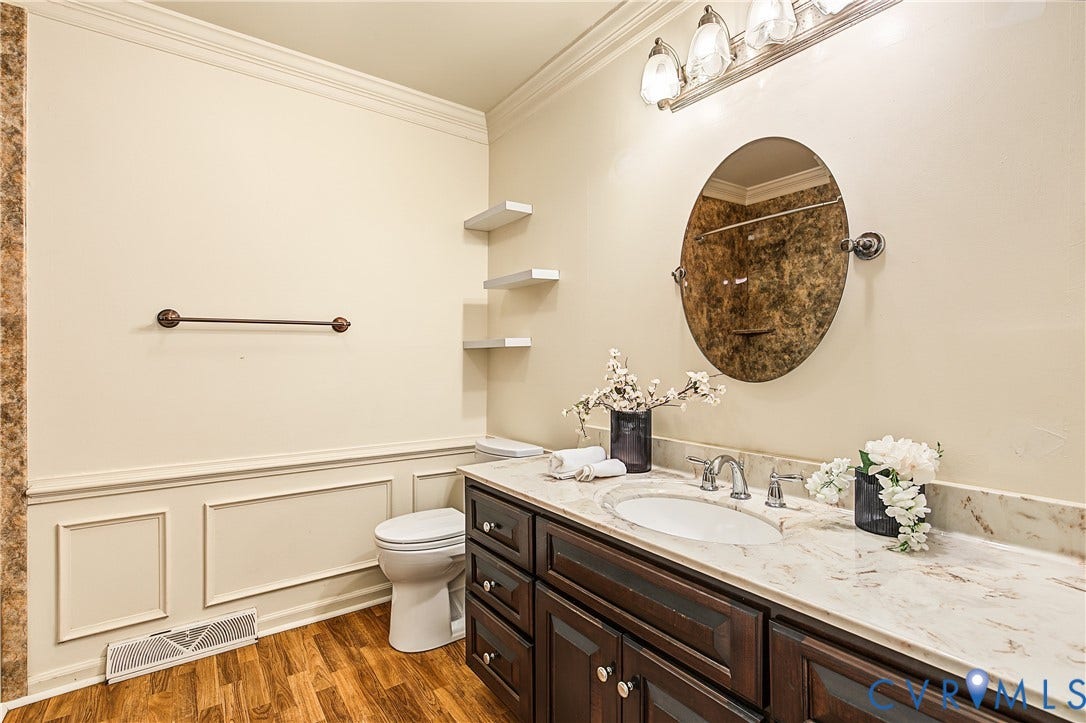 13310 Gladehill Road, Hidden Valley Estates, Chesterfield, VA 23831 Dark wood-finish vanity with an undermount sink, light-toned countertop, and an oval mirror