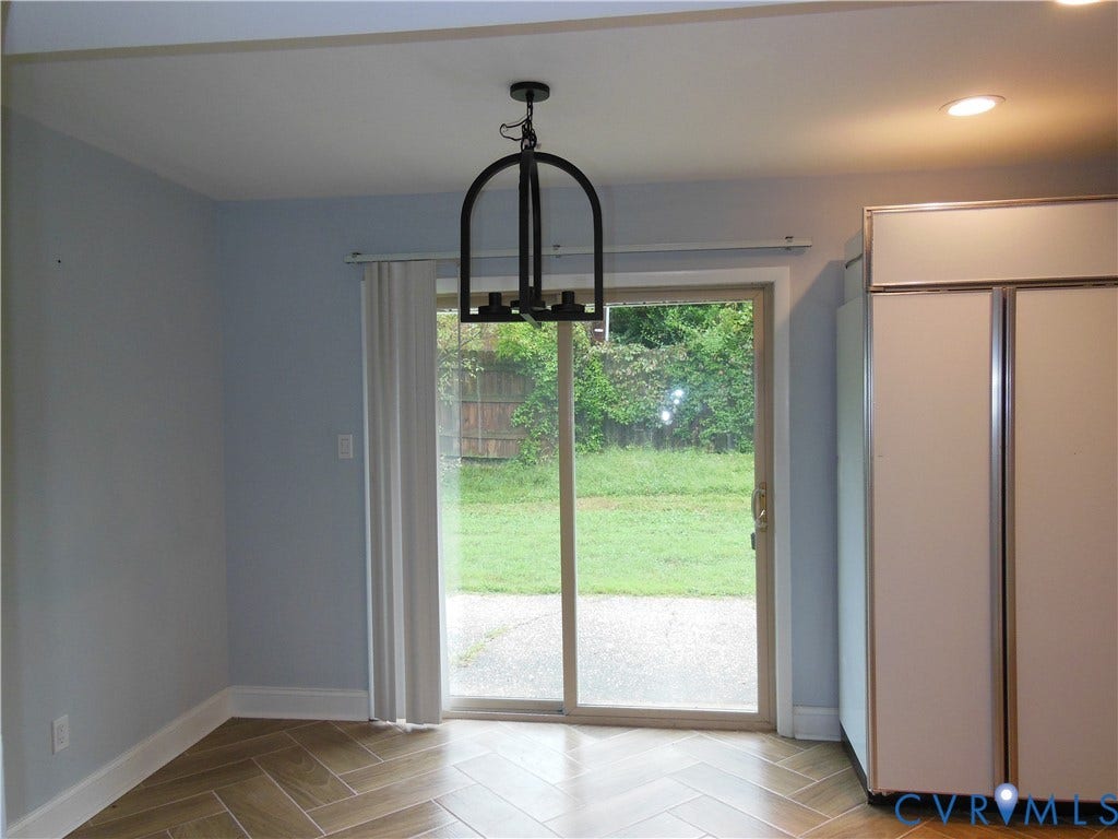 Sliding glass door, herringbone pattern tile flooring, recessed lighting, and a black chandelier