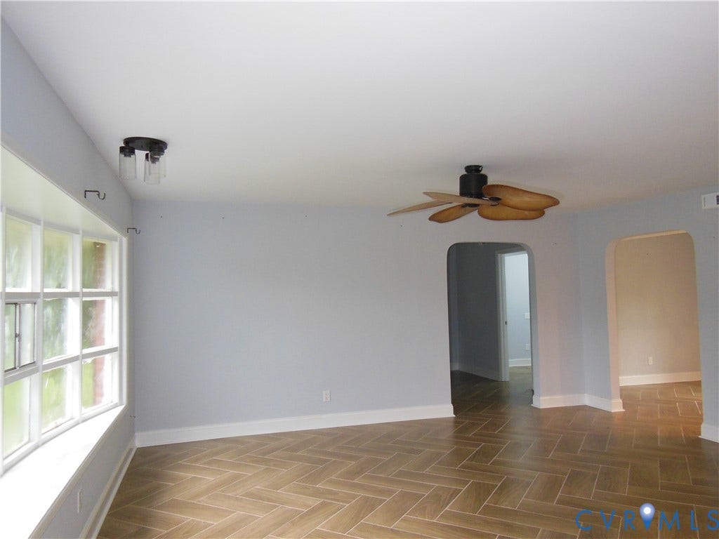 Herringbone-patterned tile flooring, bay window, ceiling fan