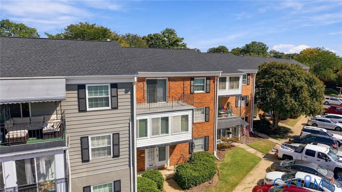 12 Snughaven Road, Hamlet, Henrico, VA 23228 Exterior featuring brick and siding finishes, multiple balconies, dark shingled roof, and paved parking area