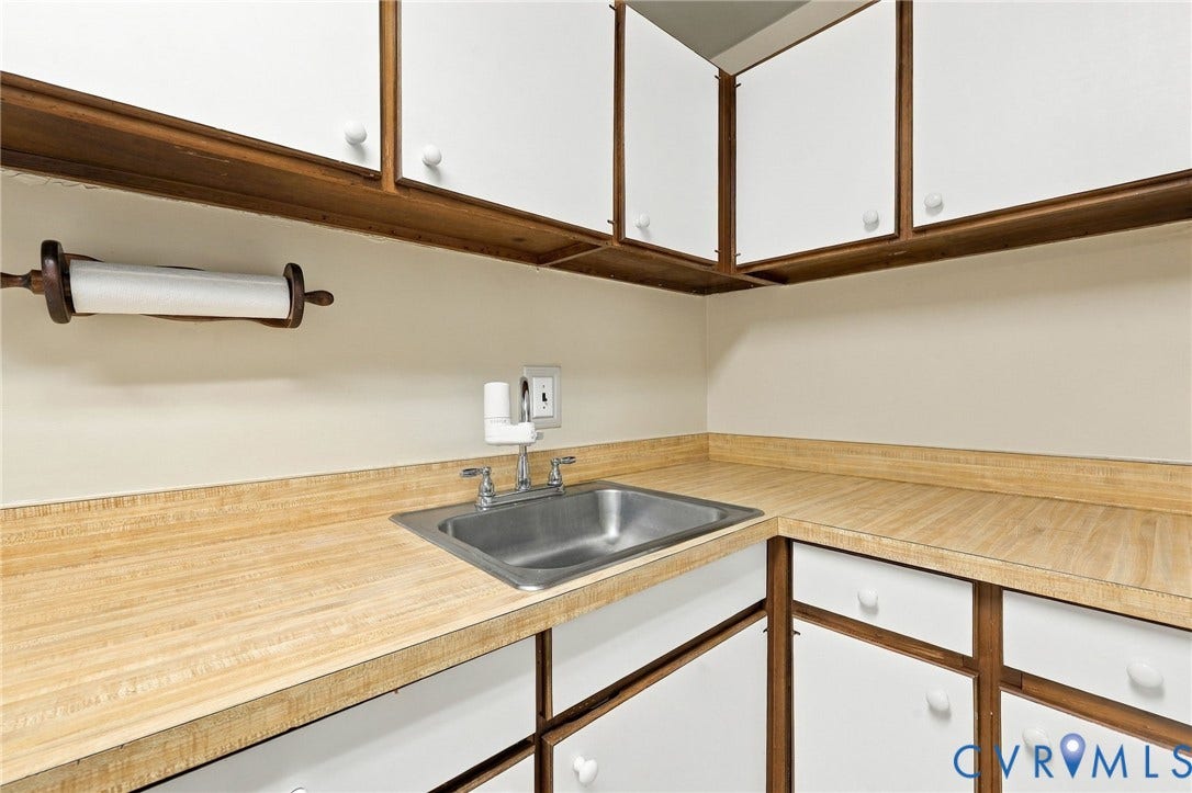 12 Snughaven Road, Hamlet, Henrico, VA 23228 Stainless steel sink, light wood-finish countertops, white cabinetry, and wood-toned framework