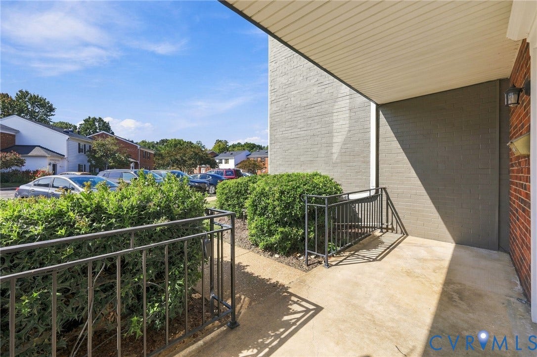 12 Snughaven Road, Hamlet, Henrico, VA 23228 Covered entry with concrete flooring, black metal railing, and brick exterior
