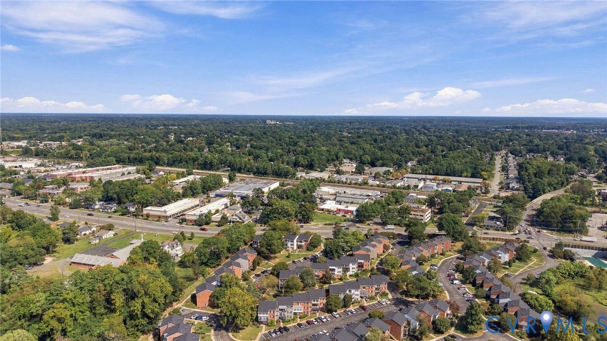 12 Snughaven Road, Hamlet, Henrico, VA 23228 Aerial perspective of a verdant residential area featuring townhomes, commercial buildings, and extensive tree canopy