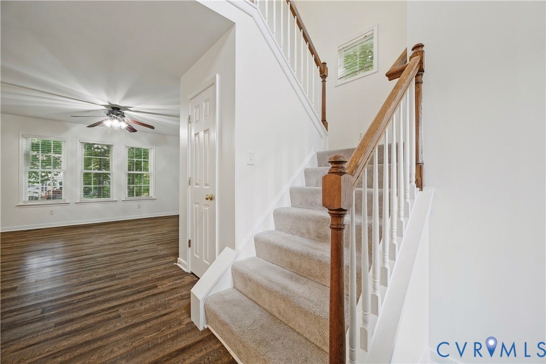15724 Winding Ash Drive, Chesterfield, VA 23832 Carpeted staircase with wood-finish handrail and white spindles, wood-finish flooring, white paneled door, and ceiling fan with lighting