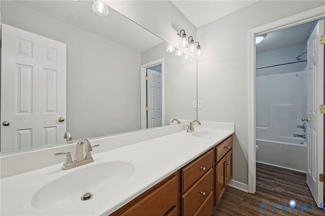 15724 Winding Ash Drive, Chesterfield, VA 23832 Double vanity with wood-finish cabinetry, integrated sinks, and brushed nickel fixtures