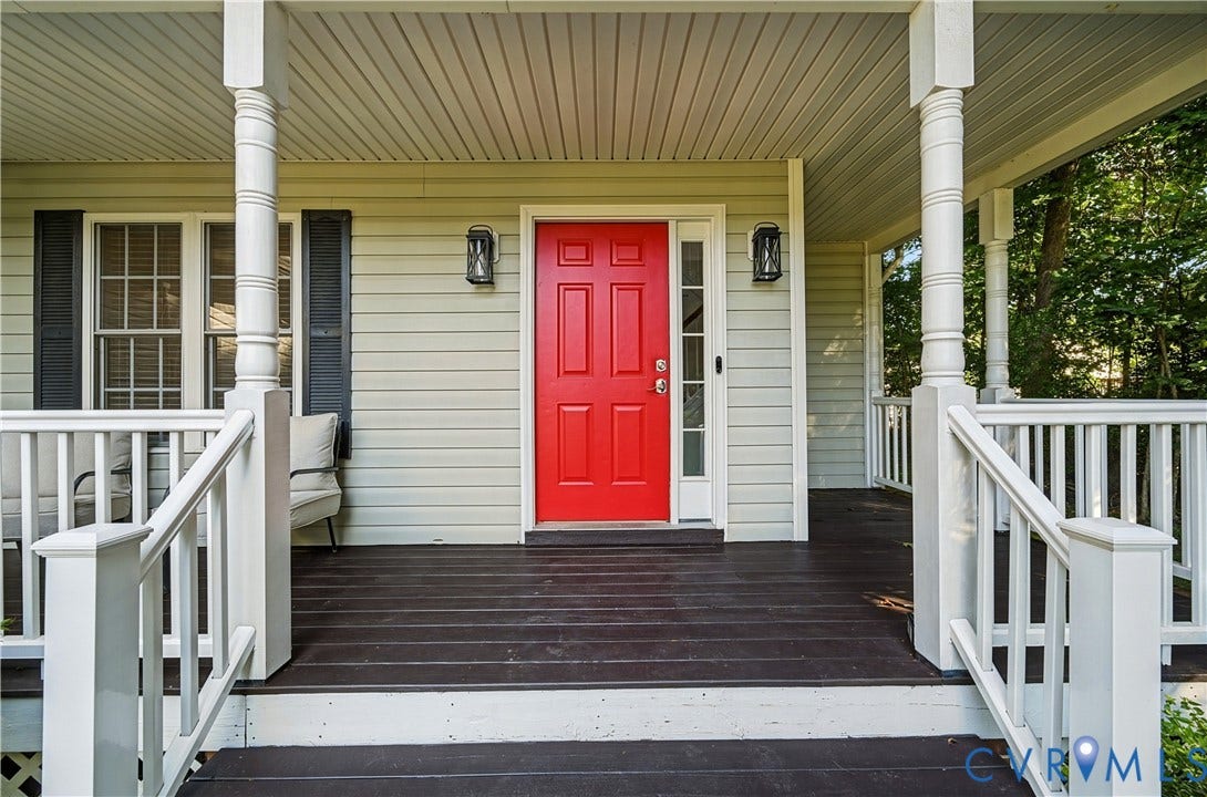 15724 Winding Ash Drive, Chesterfield, VA 23832 Inviting front porch featuring a vibrant red entry door, white railings, decorative columns, and exterior lighting fixtures