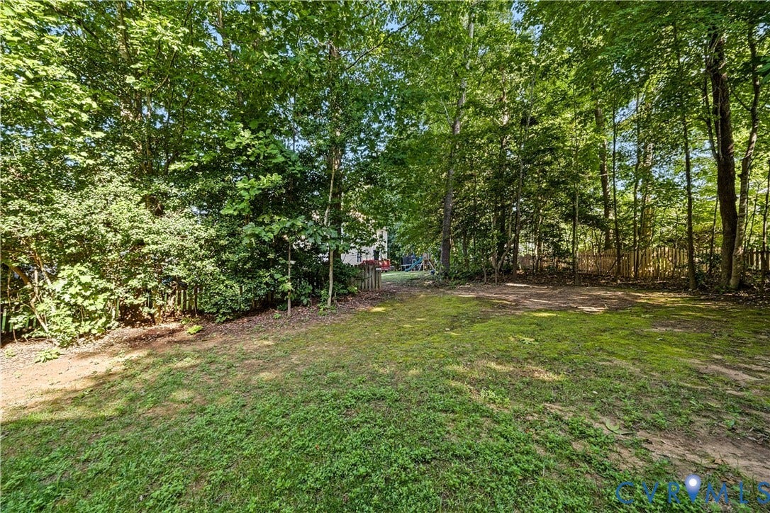 15724 Winding Ash Drive, Chesterfield, VA 23832 Expansive outdoor space featuring a lawn, mature trees, and a wood privacy fence