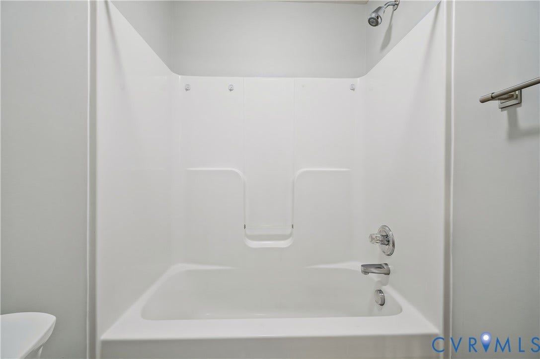 15724 Winding Ash Drive, Chesterfield, VA 23832 White shower/tub combination with integrated shelving, chrome fixtures, and a shower curtain rod
