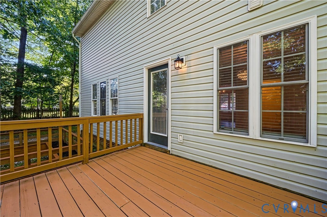 15724 Winding Ash Drive, Chesterfield, VA 23832 Expansive wooden deck with railing, light-colored horizontal siding, exterior wall lantern, double-pane windows, and a glass-paneled door