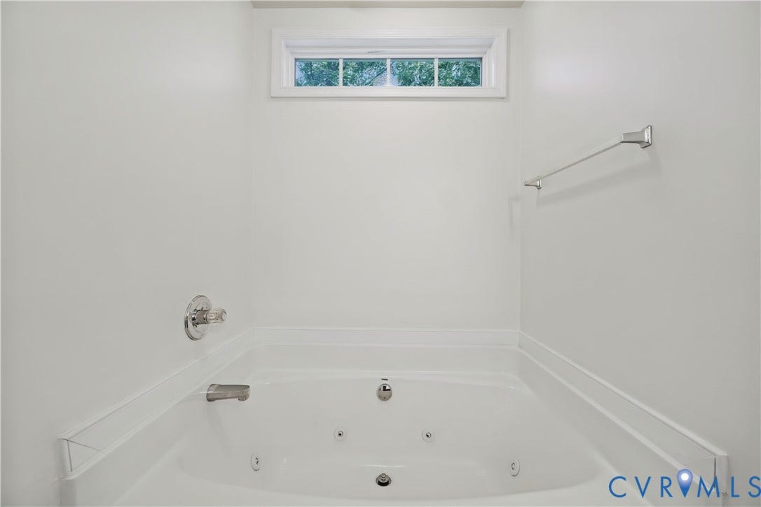 15724 Winding Ash Drive, Chesterfield, VA 23832 Jetted soaking tub with chrome fixtures, a transom window, and white wall finishes