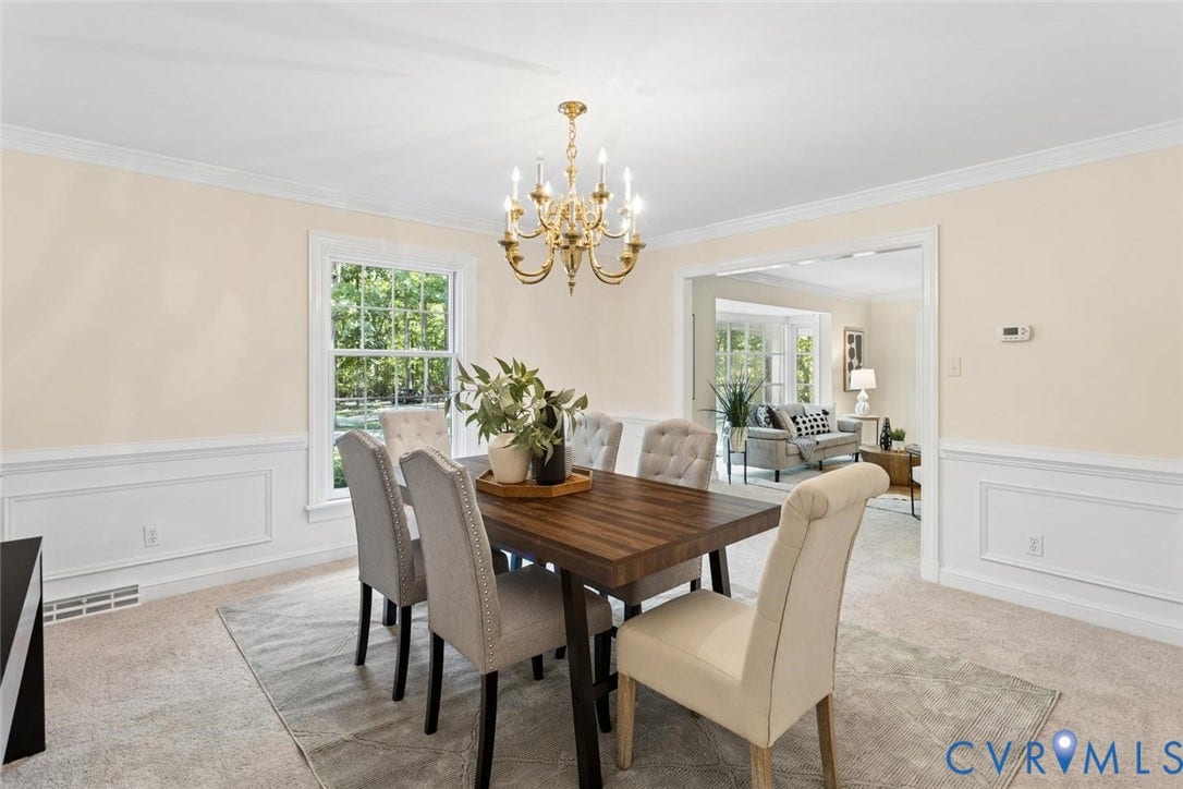 Formal dining space featuring crown molding, wainscoting, and a brass chandelier
