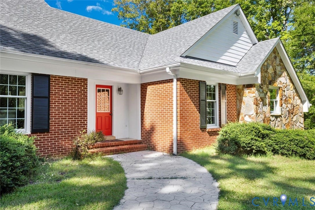Brick and stone exterior with a vibrant red entry door