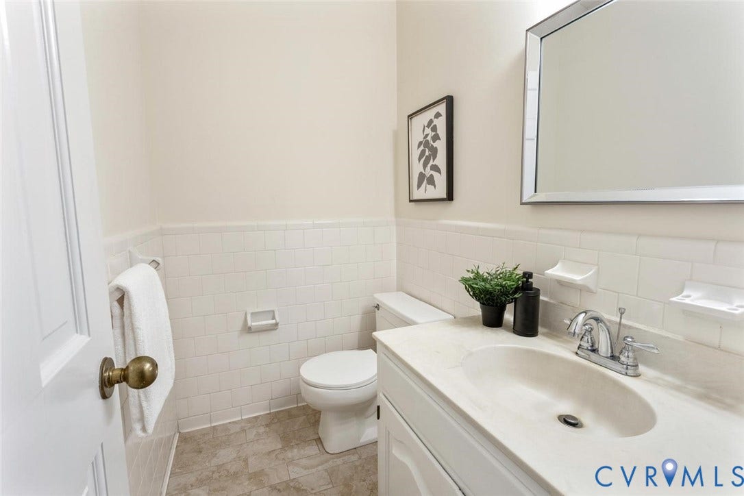 White tiled wainscoting and a white toilet