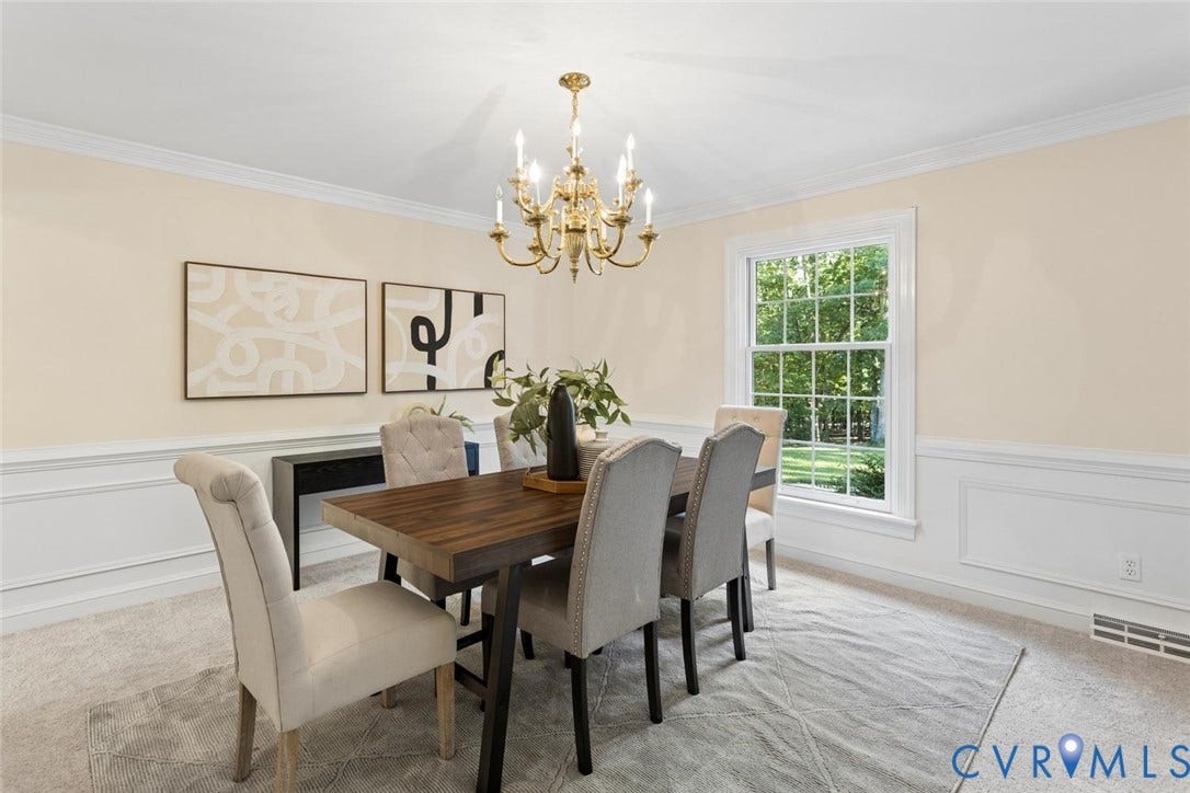 Decorative ceiling crown molding, traditional wainscoting, brass chandelier, and a large multi-pane window