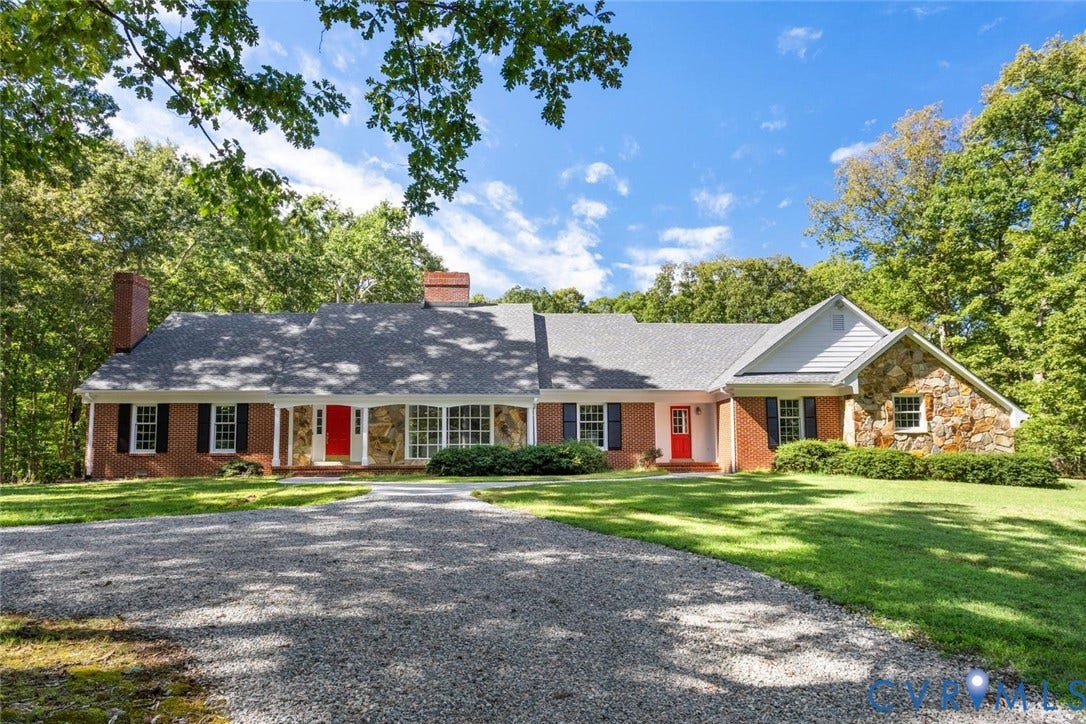 Brick and stone exterior with a gravel driveway