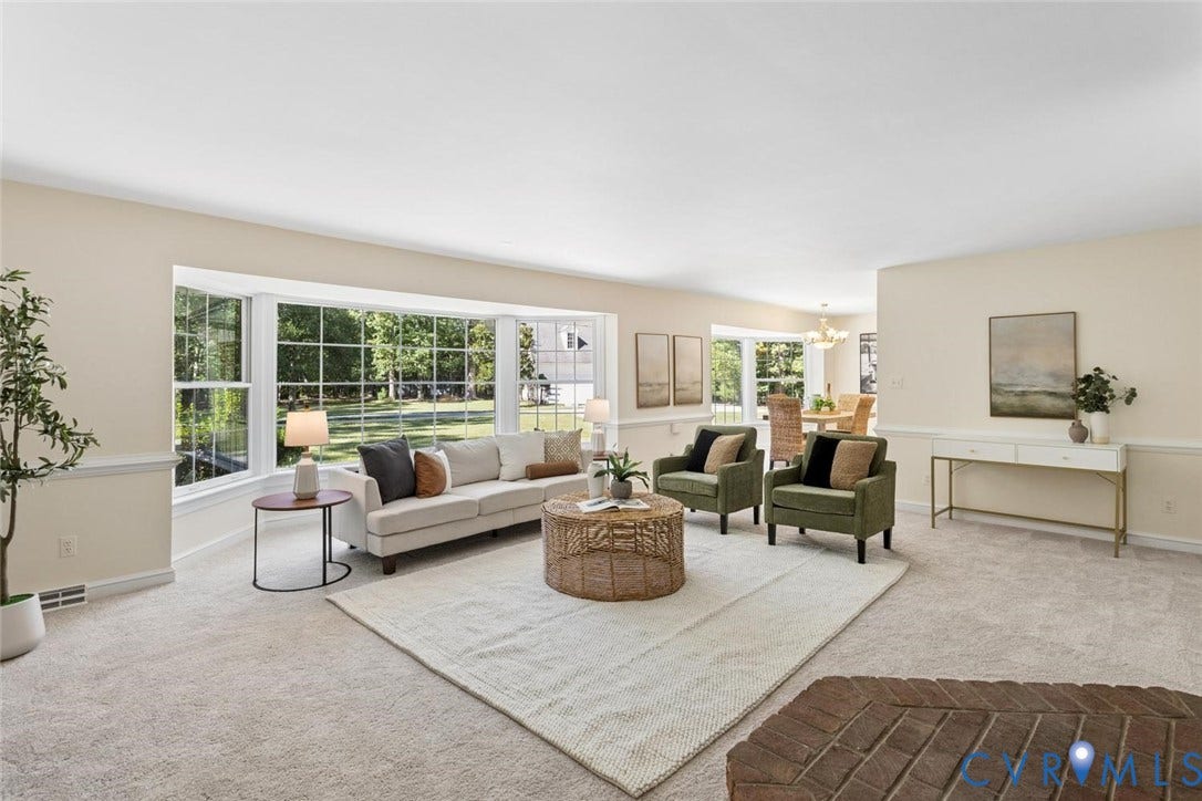 Expansive room with neutral carpeting and a large bay window