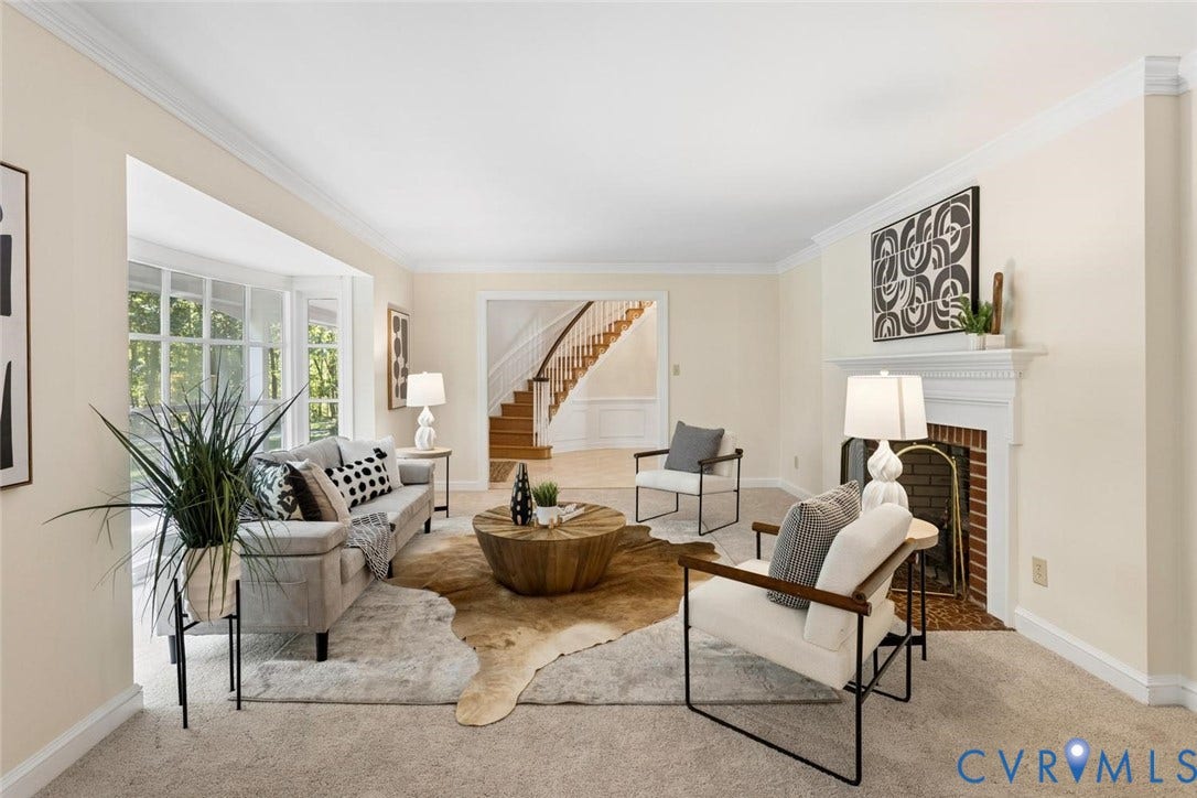 Recessed fireplace with a white mantel, bay window, light-toned wall paint, and white crown molding