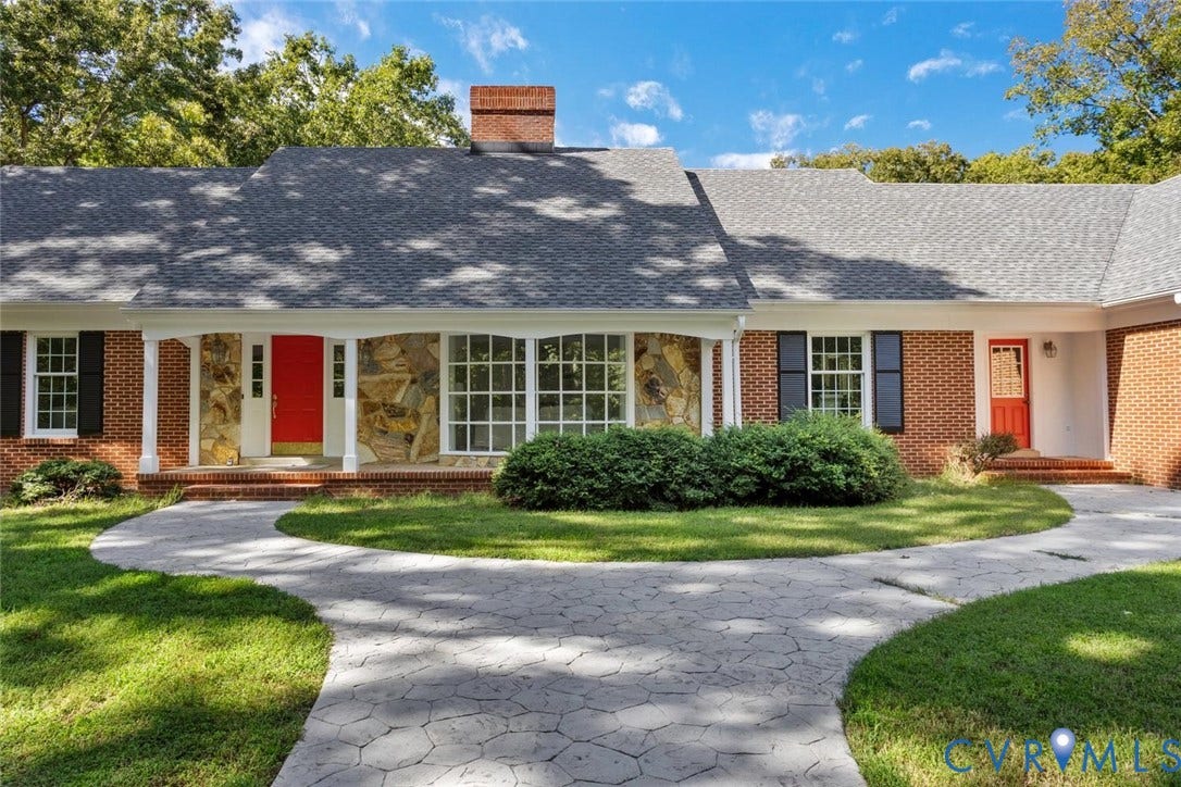 Brick and stone exterior with a covered front porch featuring white columns