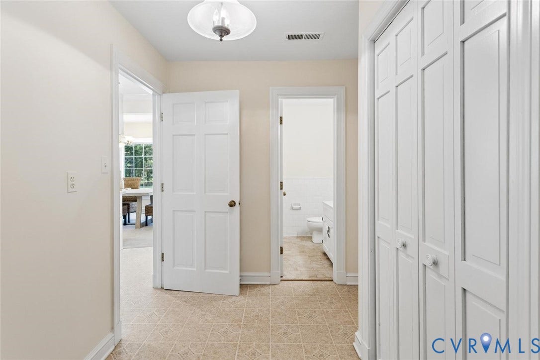 Hallway featuring neutral-toned walls, tile flooring, and white trim