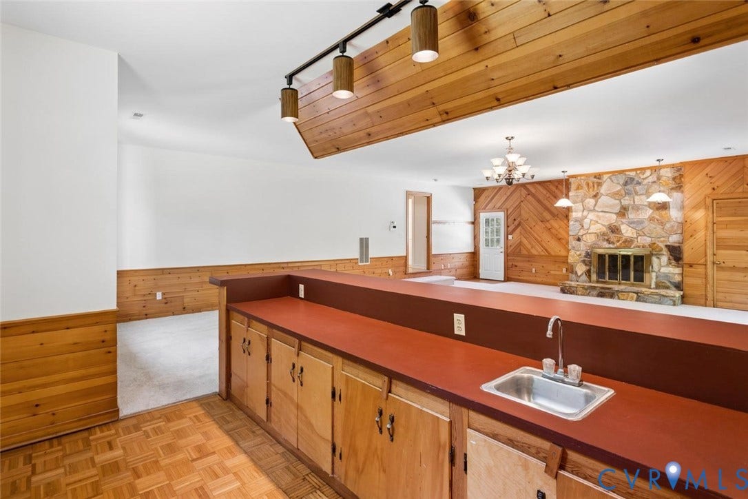 Built-in bar with wood-finish cabinetry and integrated sink