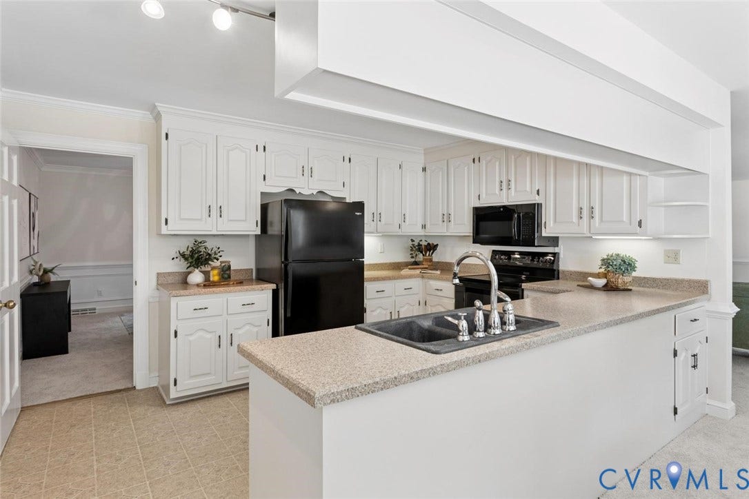 Kitchen featuring white cabinetry, a black appliance suite, speckled countertops, a double basin sink with a high-arc faucet, and tiled flooring