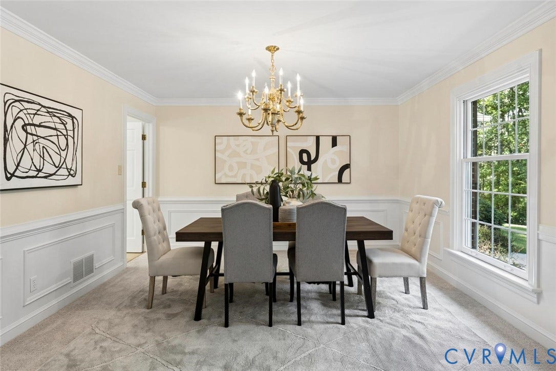 White wainscoting and crown molding complemented by a brass-finish chandelier