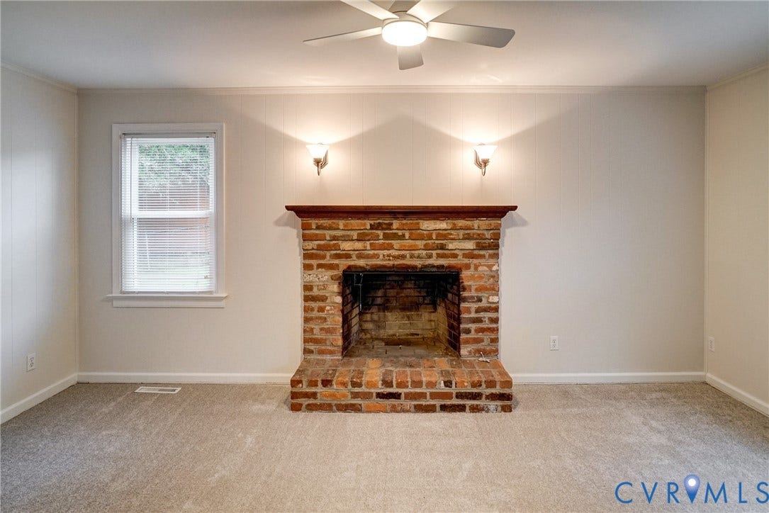 2602 Seacliff Court, Richmond, VA 23236 Brick fireplace with a wood mantel, overhead ceiling fan with lighting, wall sconces, and carpeting
