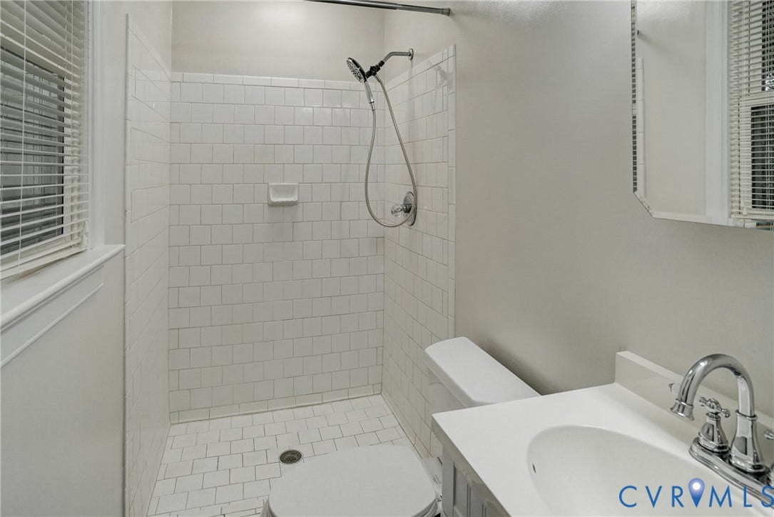 2602 Seacliff Court, Richmond, VA 23236 Primary Bathroom featuring a walk-in shower with subway tile, white vanity with integrated sink, chrome faucet, and mirrored medicine cabinet