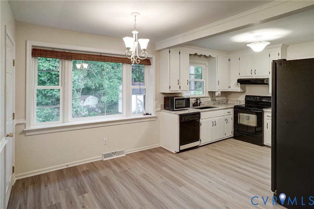2602 Seacliff Court, Richmond, VA 23236 Wood-finish flooring throughout, white cabinetry, black appliances, light-colored countertops, and a large window