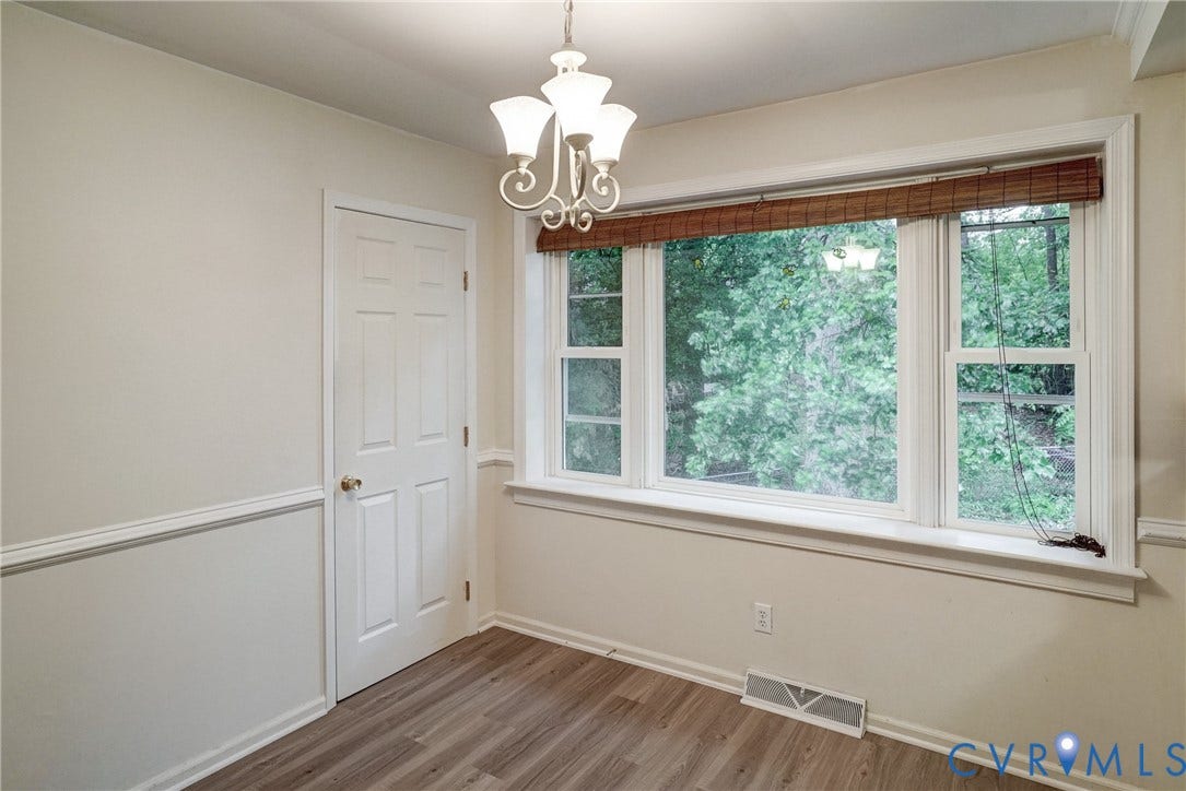 2602 Seacliff Court, Richmond, VA 23236 Wood-finish flooring, white paneled door, decorative chair rail, multi-pane window, and a chandelier with white glass shades