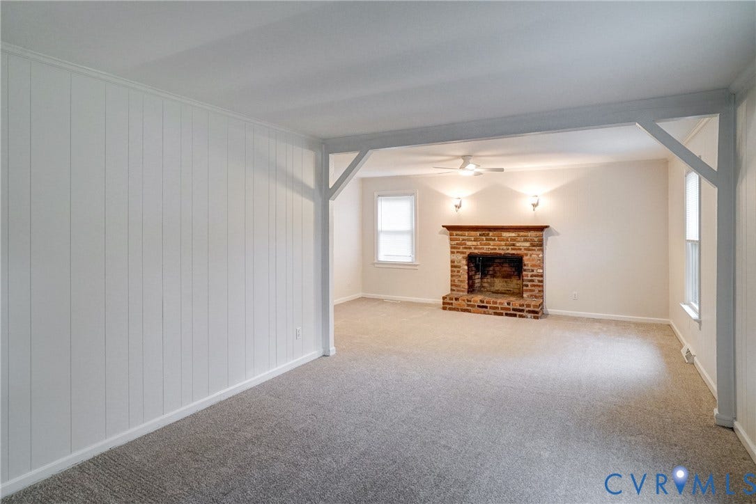 2602 Seacliff Court, Richmond, VA 23236 Carpeted interior with brick fireplace, architectural beam detailing, and paneling