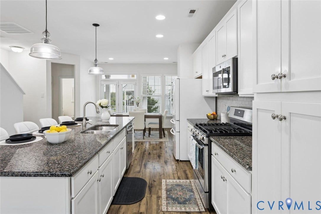 10420 Perennial Drive, Ridgefield Green Townhome, Henrico, VA 23233 Kitchen featuring an island with a sink, white cabinetry, integrated stainless steel appliances, dark stone-finish countertops, and wood-finish flooring