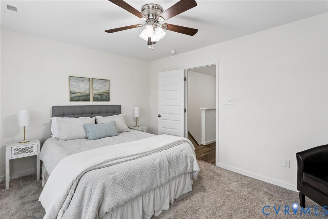 10420 Perennial Drive, Ridgefield Green Townhome, Henrico, VA 23233 Tray ceiling with a ceiling fan light fixture, carpeted flooring, white paneled door, and neutral wall tones