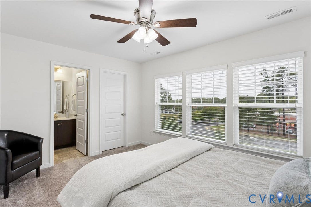 10420 Perennial Drive, Ridgefield Green Townhome, Henrico, VA 23233 Light-colored carpeting, three windows with horizontal blinds, and a ceiling fan with integrated lighting