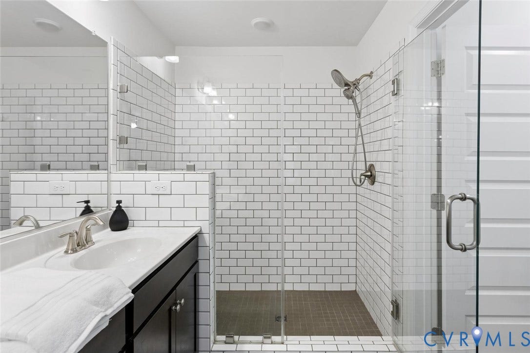 10420 Perennial Drive, Ridgefield Green Townhome, Henrico, VA 23233 Bathroom featuring a glass-enclosed shower, subway tile accents, a vanity with an integrated sink, and brushed nickel fixtures