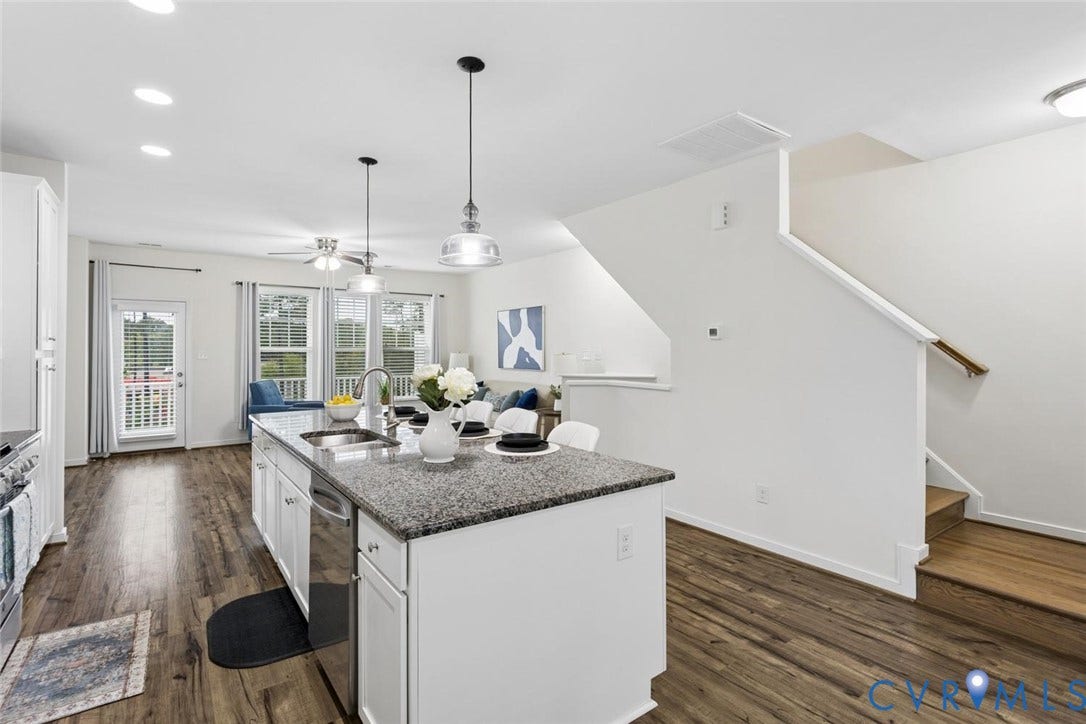 10420 Perennial Drive, Ridgefield Green Townhome, Henrico, VA 23233 Open-concept kitchen with a large island, stainless steel appliances, wood-finish flooring, and white cabinetry