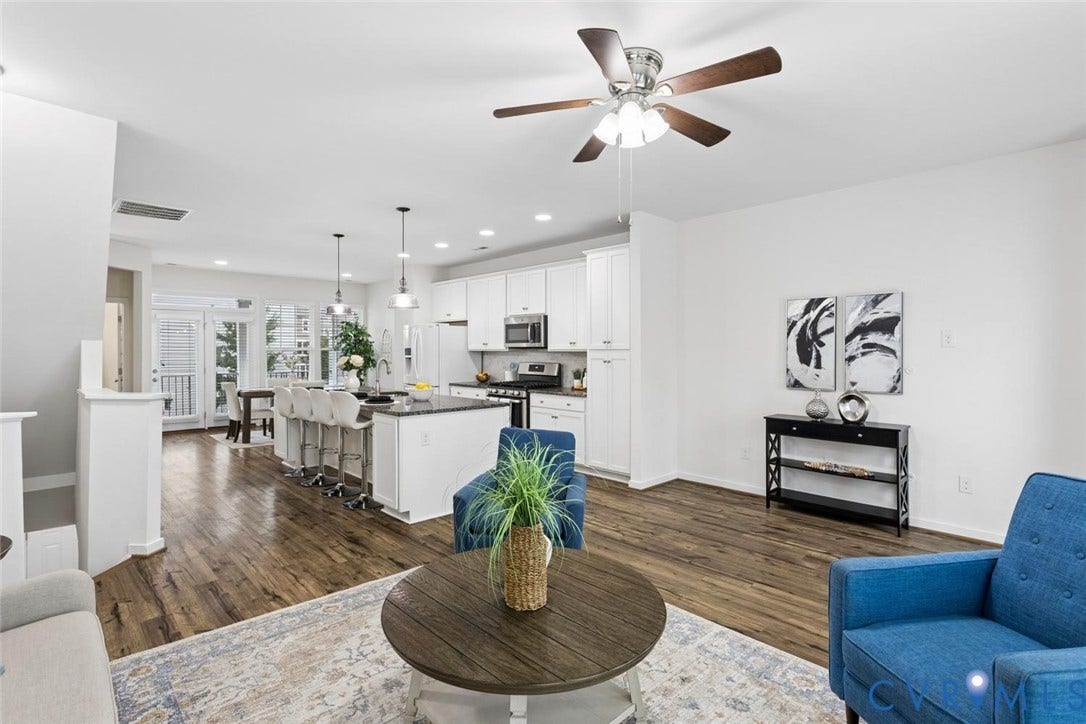 10420 Perennial Drive, Ridgefield Green Townhome, Henrico, VA 23233 Wood-finish flooring throughout, white cabinetry, integrated stainless steel appliances, breakfast bar island, and pendant lighting