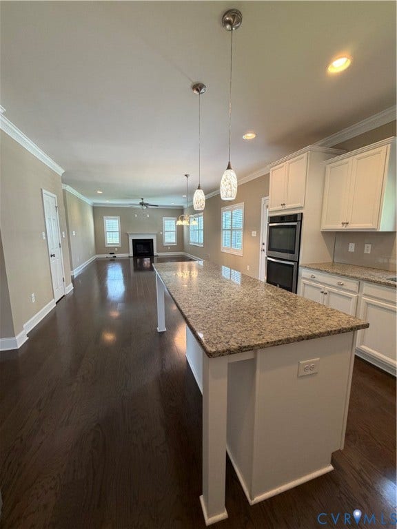 12146 Elnora Lane, Glen Allen, VA 23059 Spacious kitchen island with stone-finish countertop, wood-finish flooring, white cabinetry, and built-in double oven